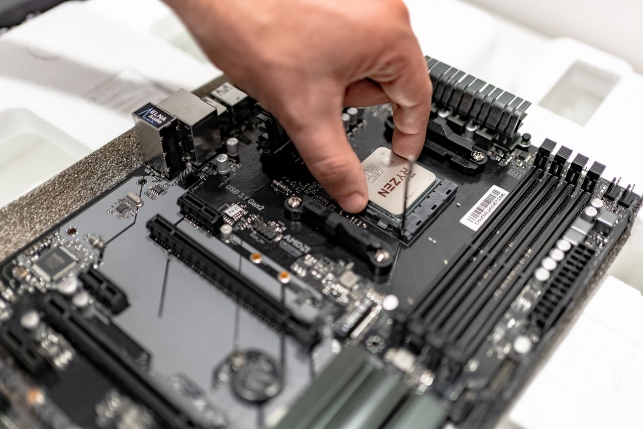 why-choose-us-02 Person's hand installing a CPU on a motherboard, showcasing PC maintenance and repair.